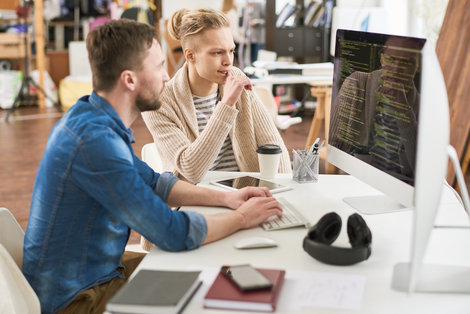 Hipster programming team analyzing code of website